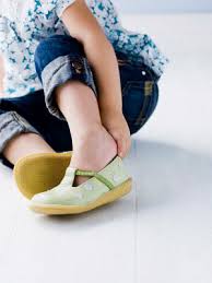 Preschooler putting on yellow shoes 